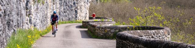 Cyclistes sur la véloroute V87 dans la côte de Gluges à Creys