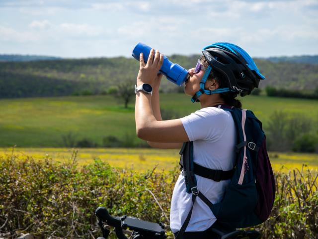 Pause boisson d'une cycliste sur la V87 à Magès