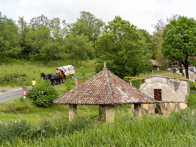 La calèche passe devant un lavoir